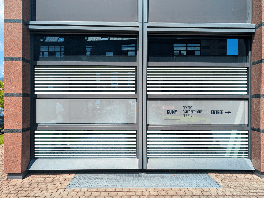 entrée du Centre Ostéopathique de Nyon avec signalétique CONY sur la façade en adhésif