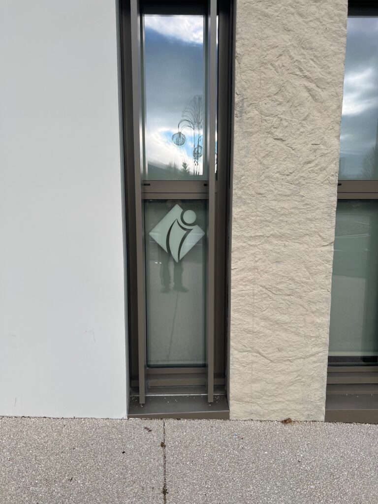 adhésif logo dépoli sur vitrage bâtiment